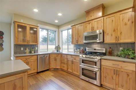 alder wood cabinets with black stainless steel appliances|alder cabinets with white countertops.